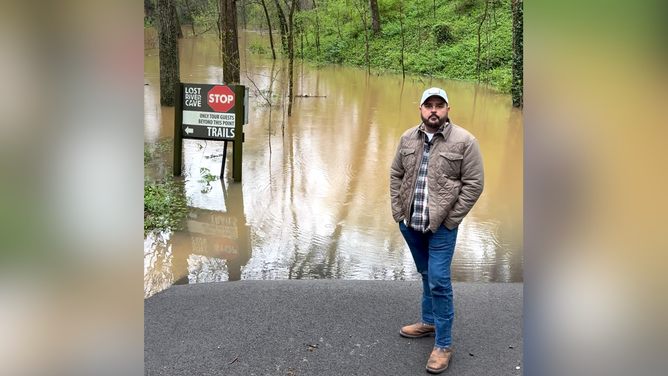 Lost River Cave CEO Justin Jennings stands at the waterline of the recent floods over the weekend.